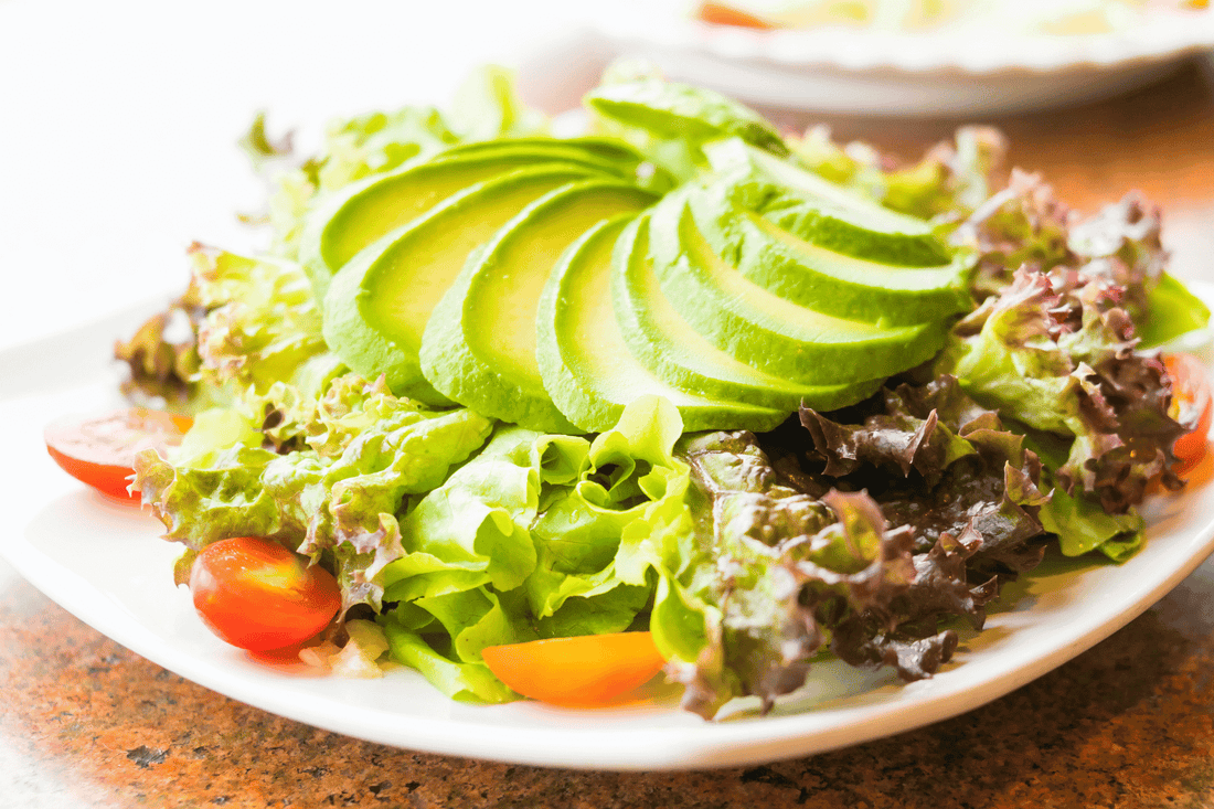 Eine Schüssel mit Avocado Salat, Tomate und Mangoessig