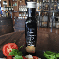 Eine Flasche Aceto Balsamico Essig mit Tomaten und Mozzarella