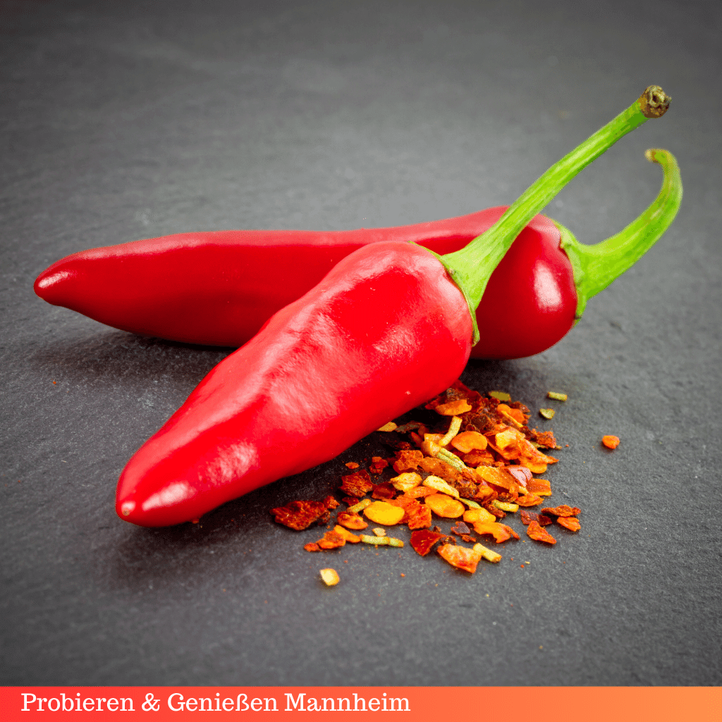 zwei rote Chili Schoten mit Chilipulver