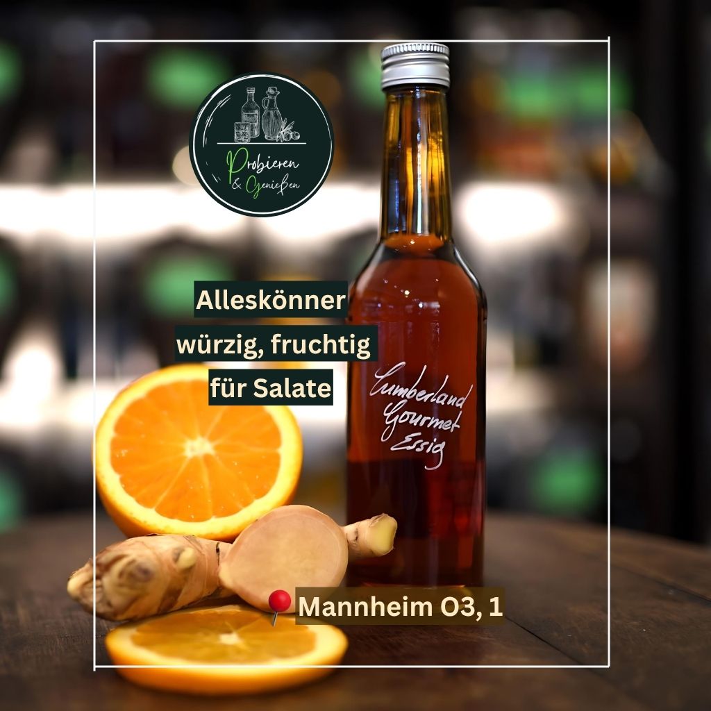 Eine Glasflasche Cumberland Essig für Kartoffelsalat, dekoriert mit frischen Orangen und Ingwer auf einem Holztisch bei Feinkost Mannheim in der Innenstadt.
