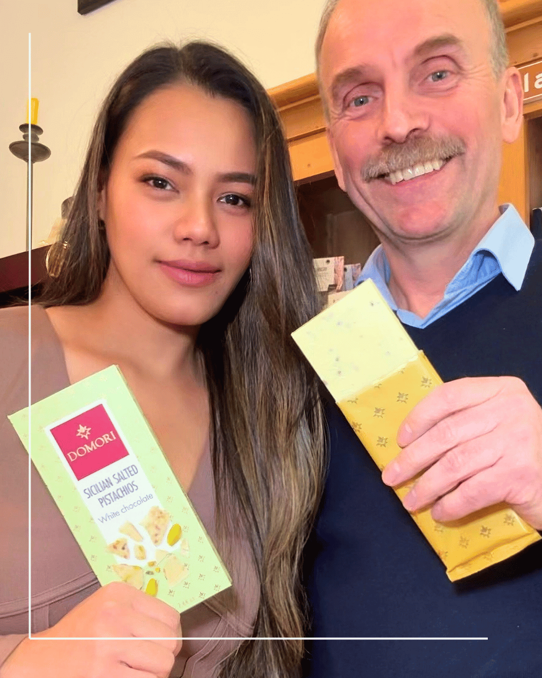 Mann und Frau zeigen die Domori weiße Schokolade mit Pistazien in Mannheim Quadrate