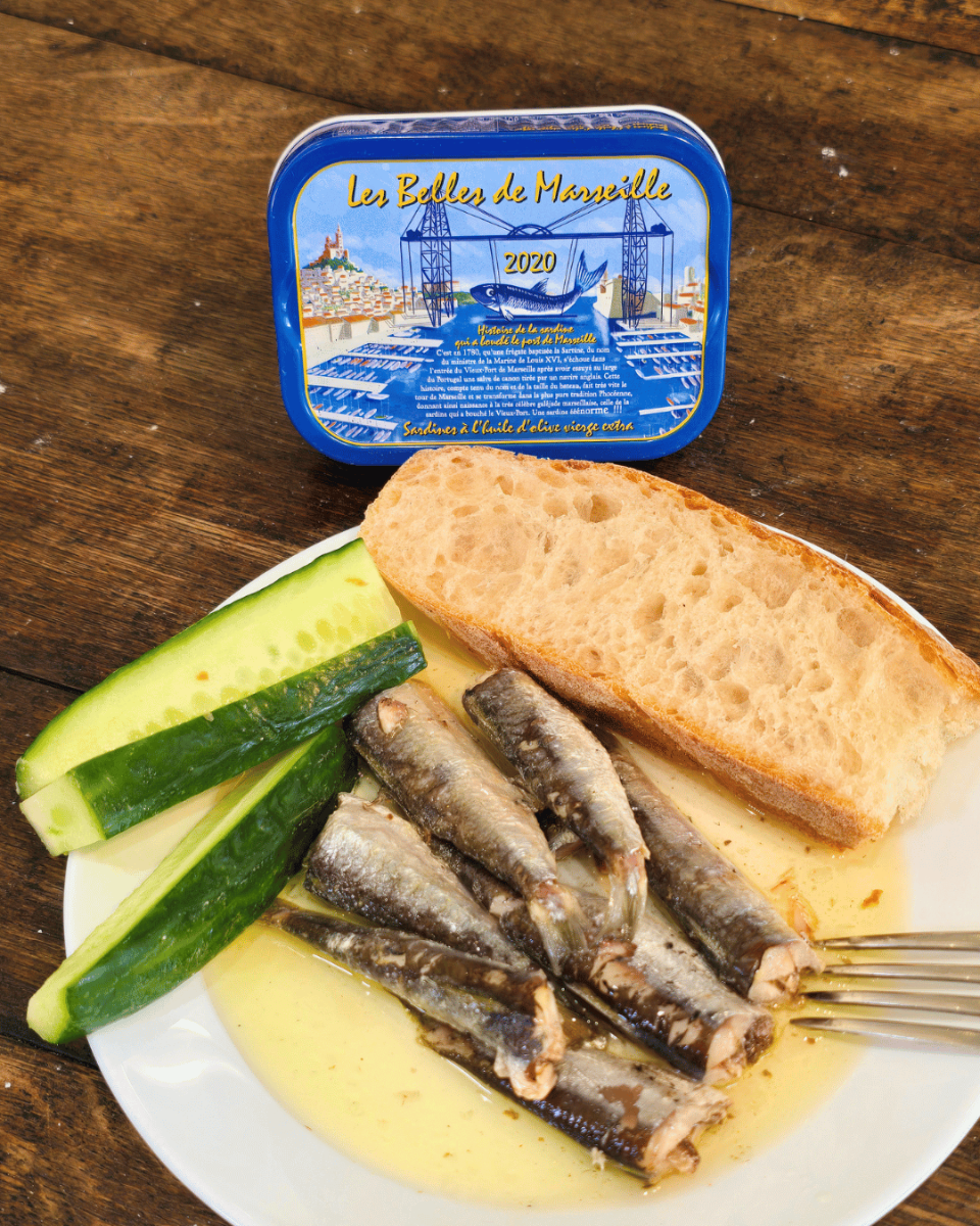 Mediterrane Sardinen in Olivenöl mit Baguette auf weißem Teller. La Belle de Marsaille Jahrgangssardinen in Mannheim.