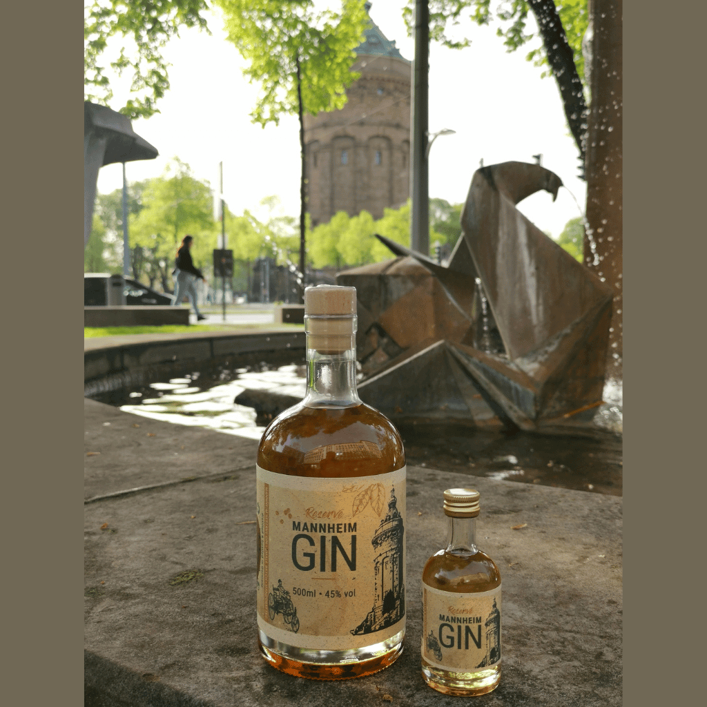 Zwei Flaschen brauner Mannheim Gin vor dem Mannheimer Wasserturm